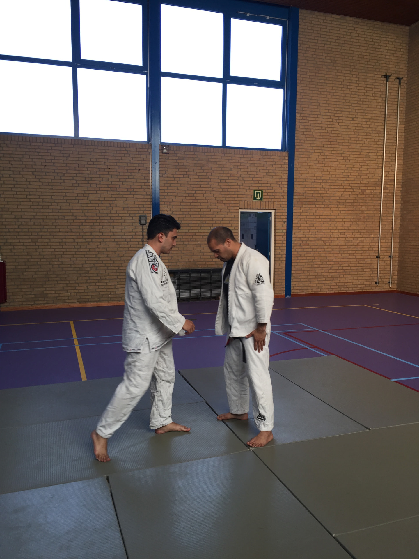 Two practitioners in gi facing each other before training